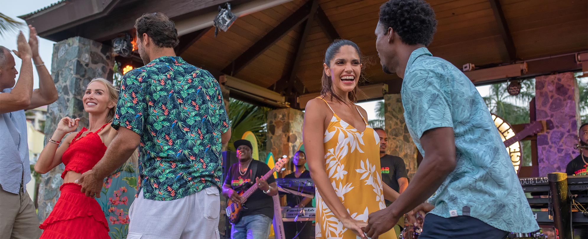  Five people dancing to a live band outside at a Club Wyndham resort. 