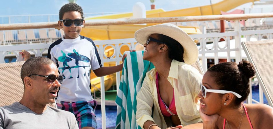 A family of four sits by the pool on a cruise ship, after using their Margaritaville points to book a cruise.