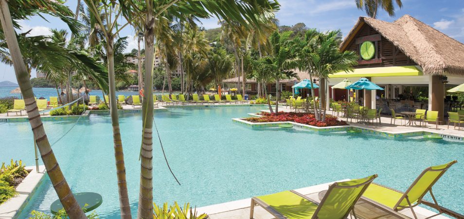 Bright green pool chairs and palms surround the pool and tiki bar of Margaritaville Vacation Club by Wyndham - St. Thomas.