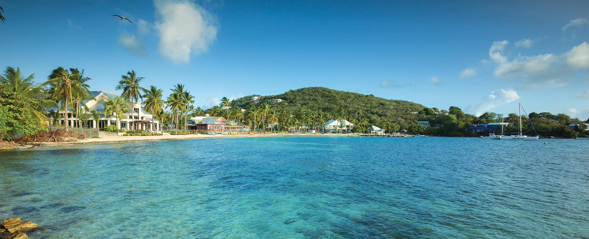 A view of the exterior of Margaritaville Vacation Club by Wyndham - St. Thomas from the clear, blue ocean. 