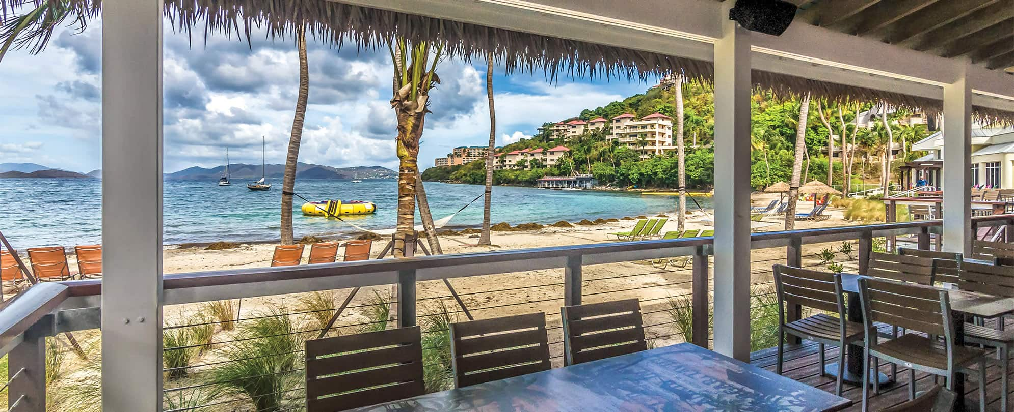 Patio tables and chairs overlooking the ocean at the restaurant at Margaritaville Vacation Club by Wyndham - St. Thomas.